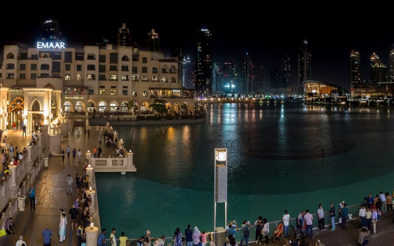 The Dubai Fountain lake and Souk Al Bahar in front of Dubai Mall at night